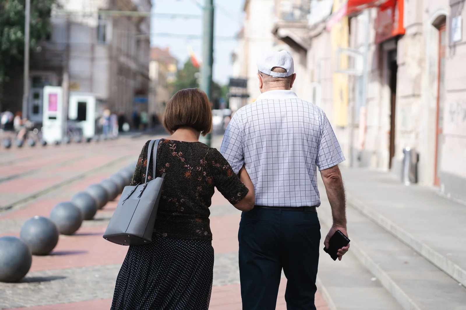 Casal mais velho caminhando juntos por uma rua