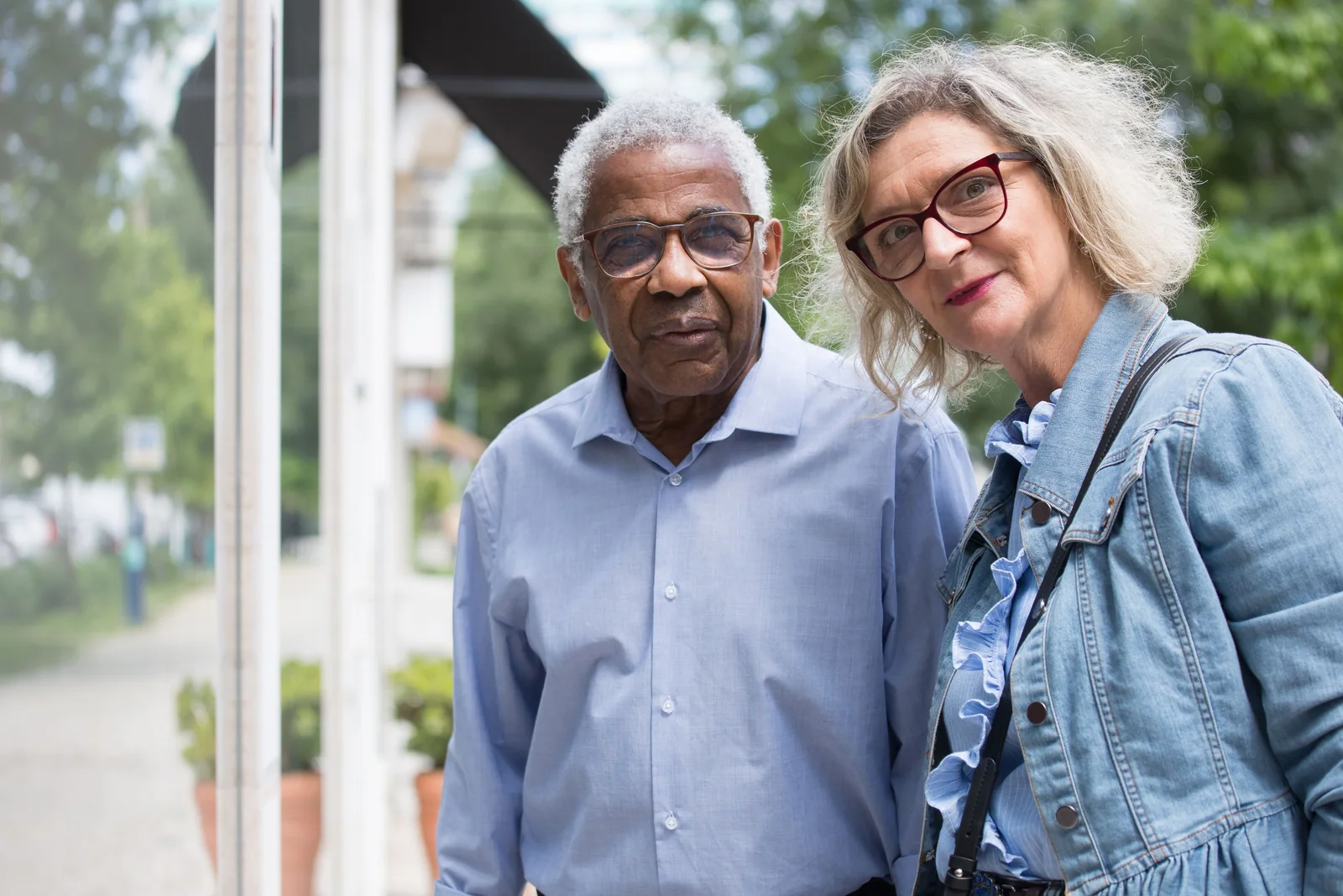 Casal mais velho em pé ao ar livre, olhando para a câmera