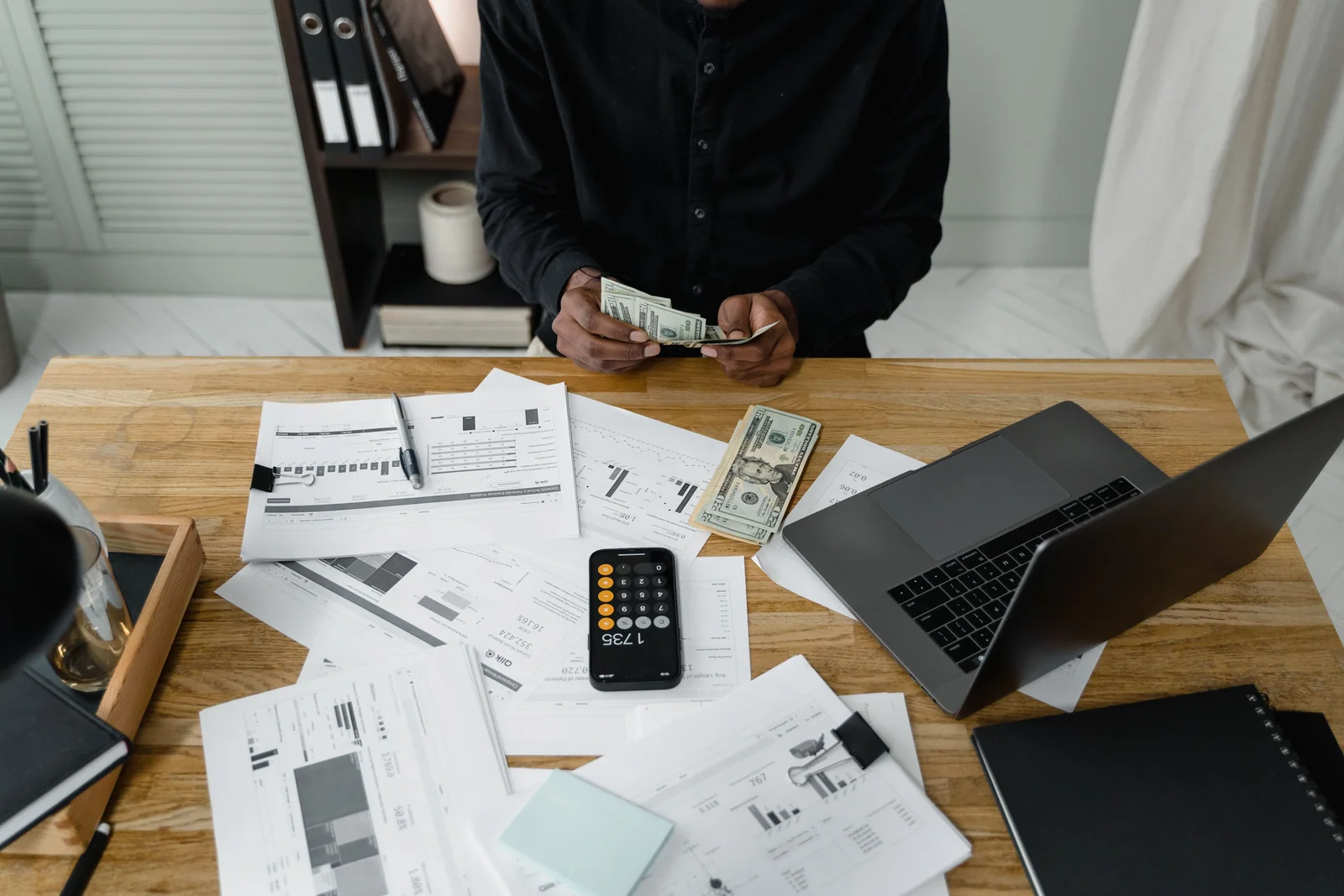 Pessoa contando dinheiro e organizando o planejamento financeiro