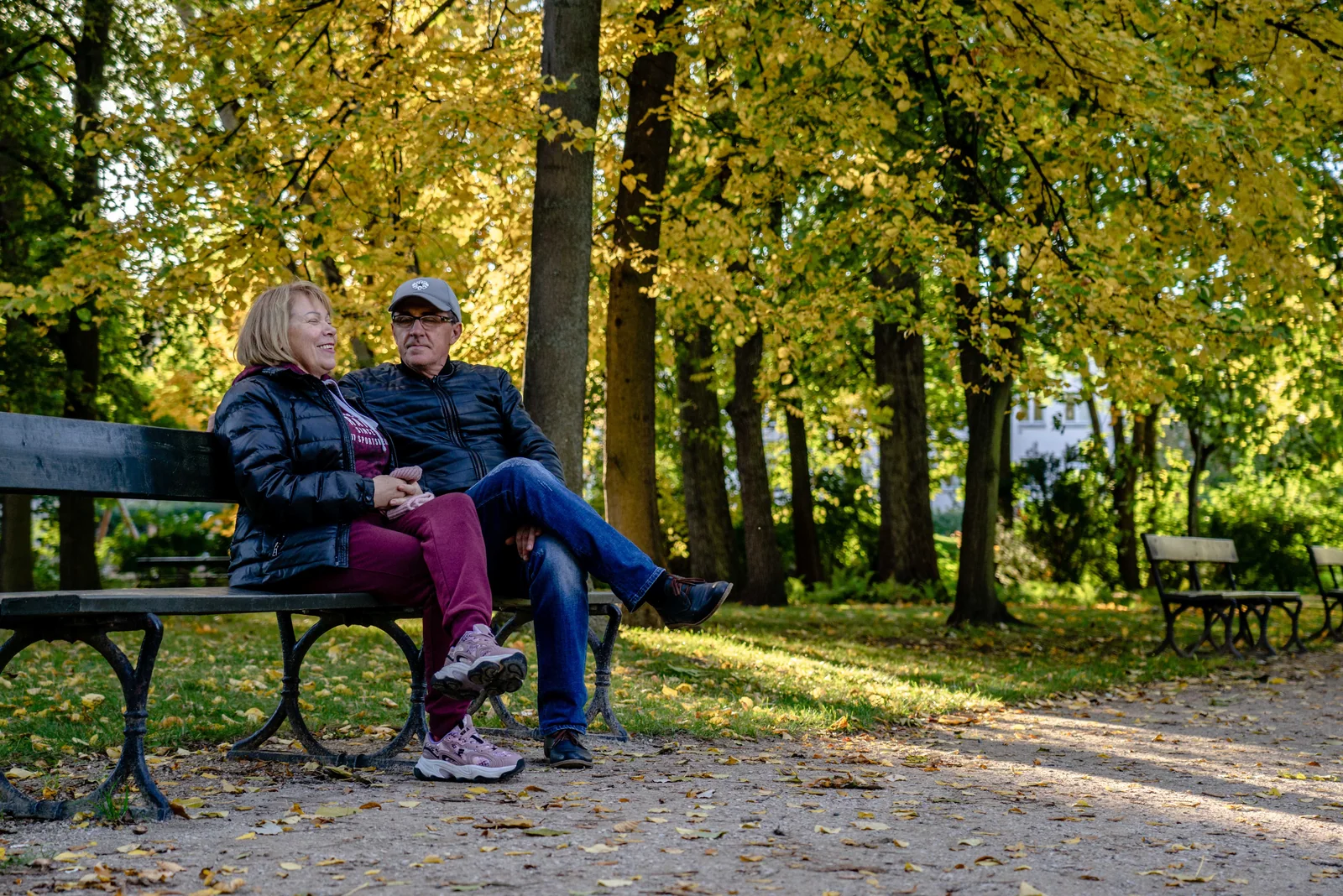 Casal sentado em um banco de parque no outono