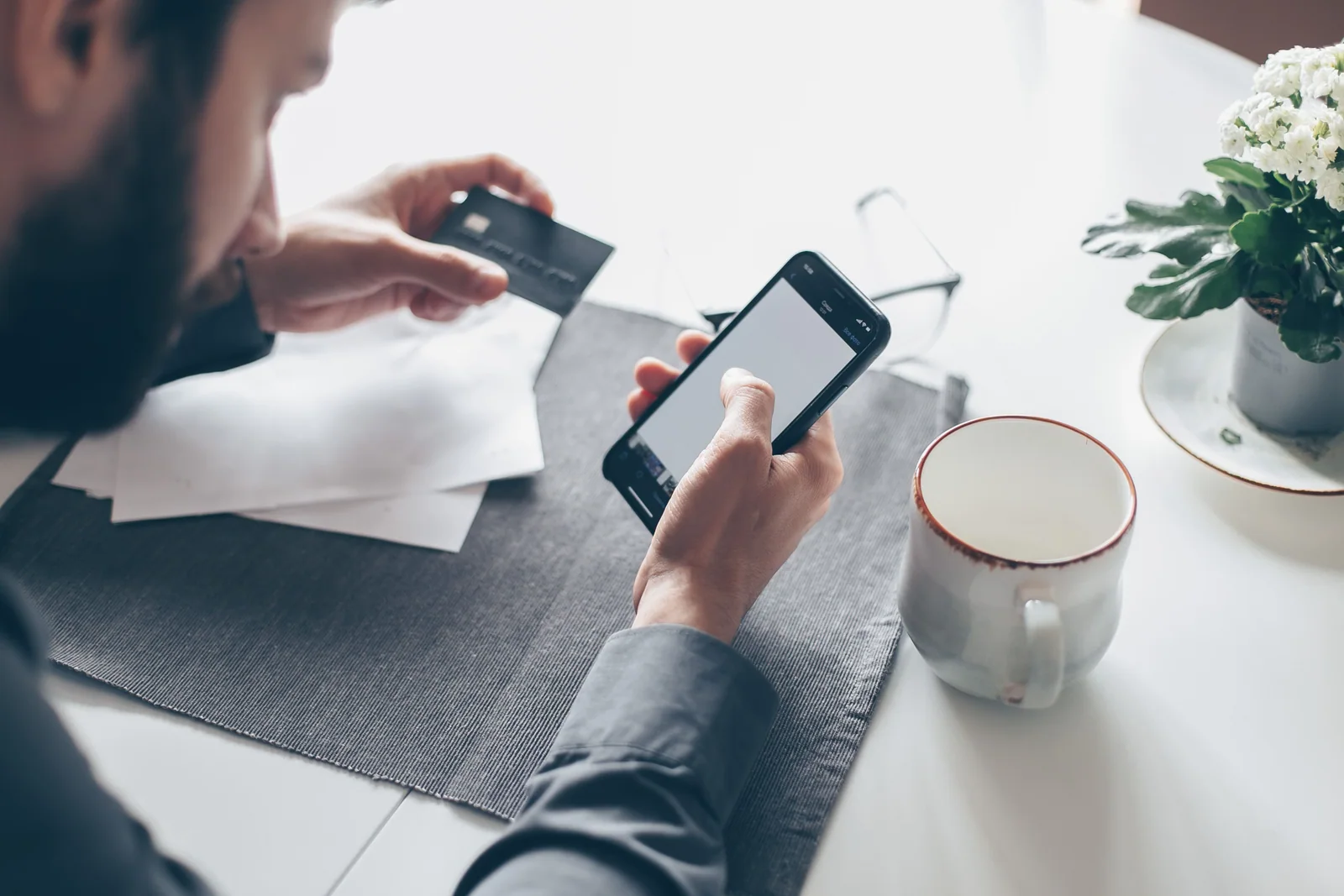 Pessoa conferindo uma operação financeira no celular antes de usar o cartão