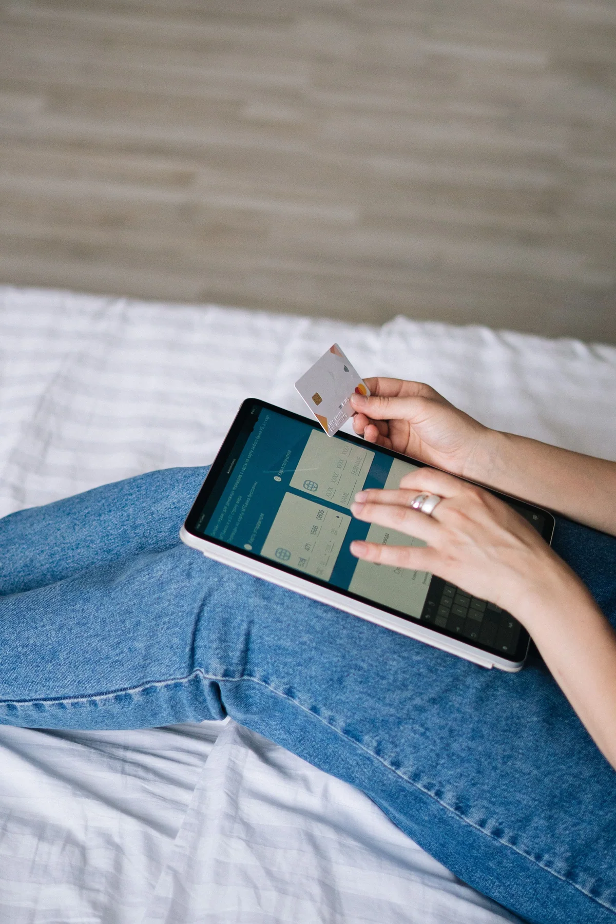 Pessoa revisando dados de pagamento em um tablet enquanto segura um cartão
