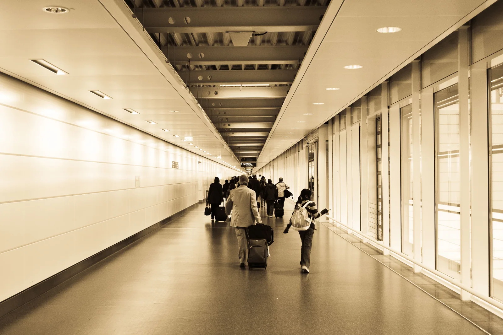 Viajantes caminhando por um terminal de aeroporto com suas malas