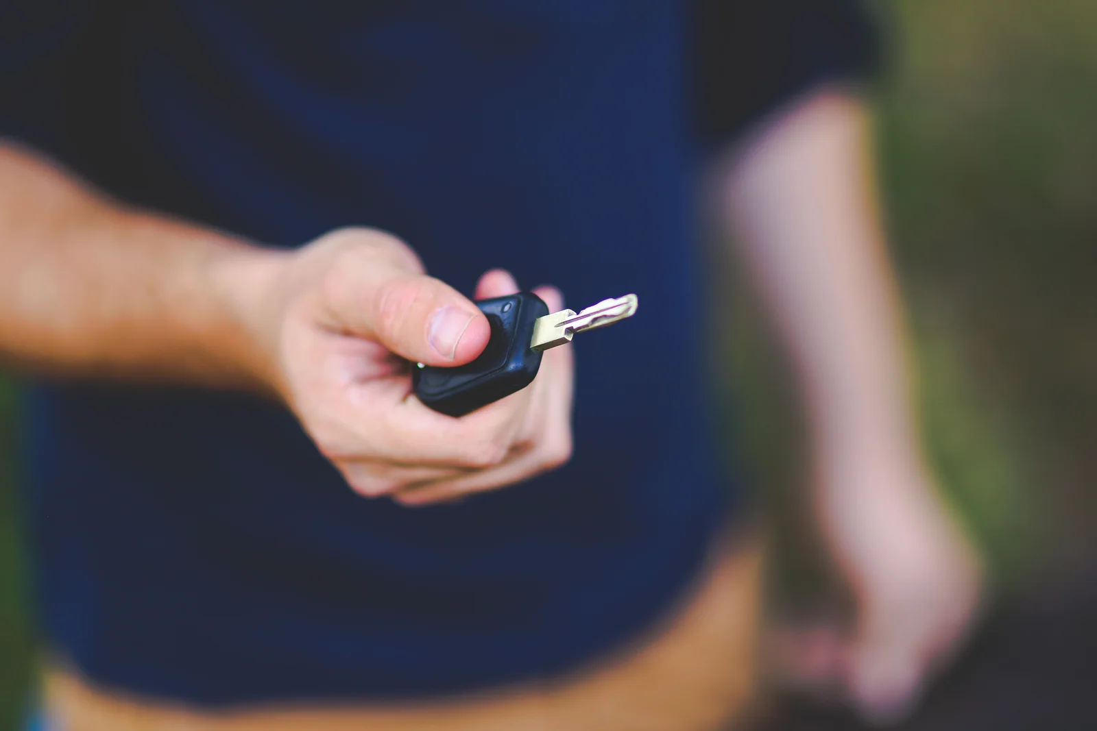Mão segurando a chave de um carro ao ar livre