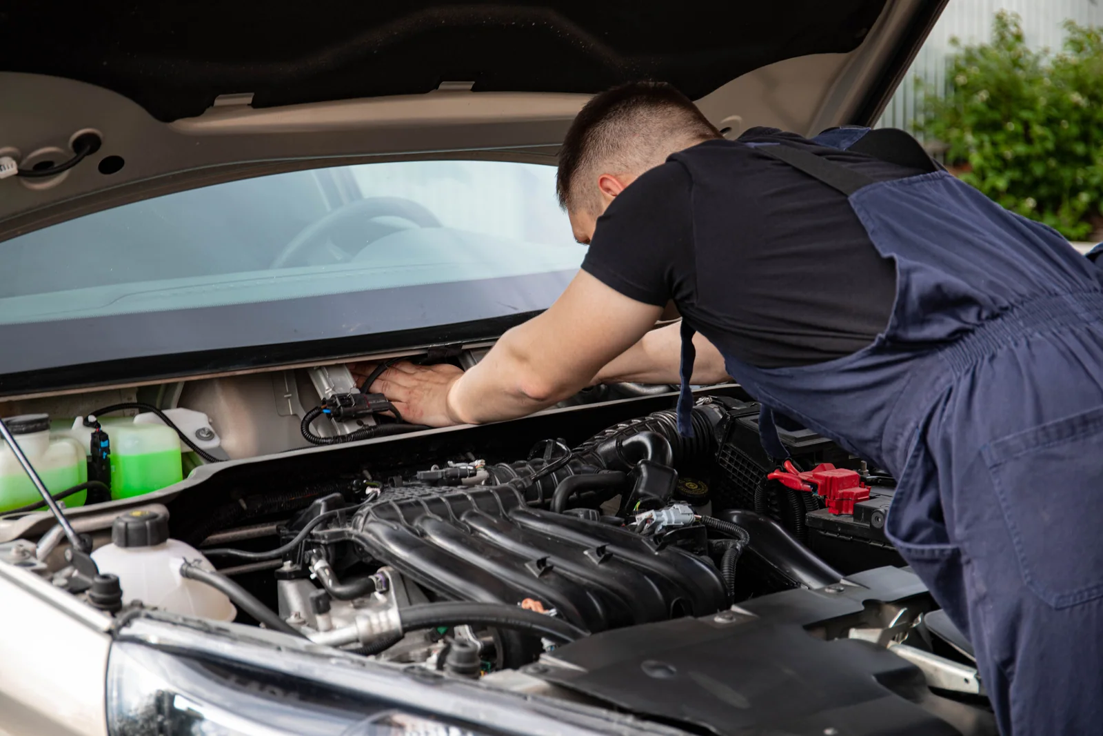 Mecânico examinando componentes no compartimento do motor