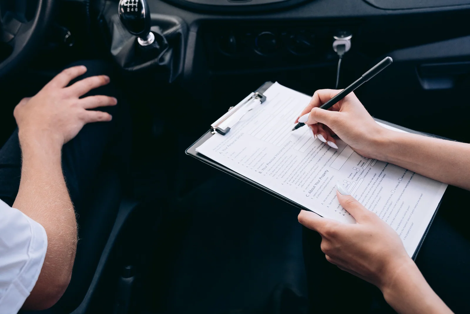 Pessoa revisando a documentação de compra dentro de um carro