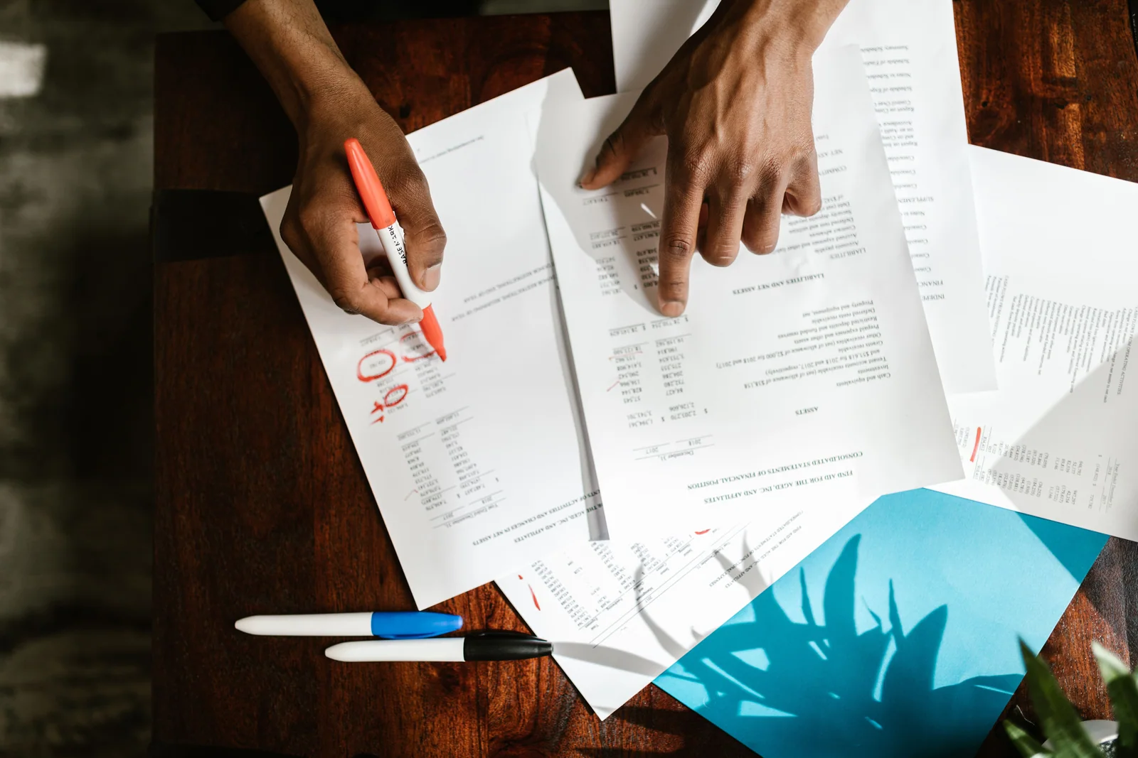 Pessoa comparando documentos e valores de uma proposta