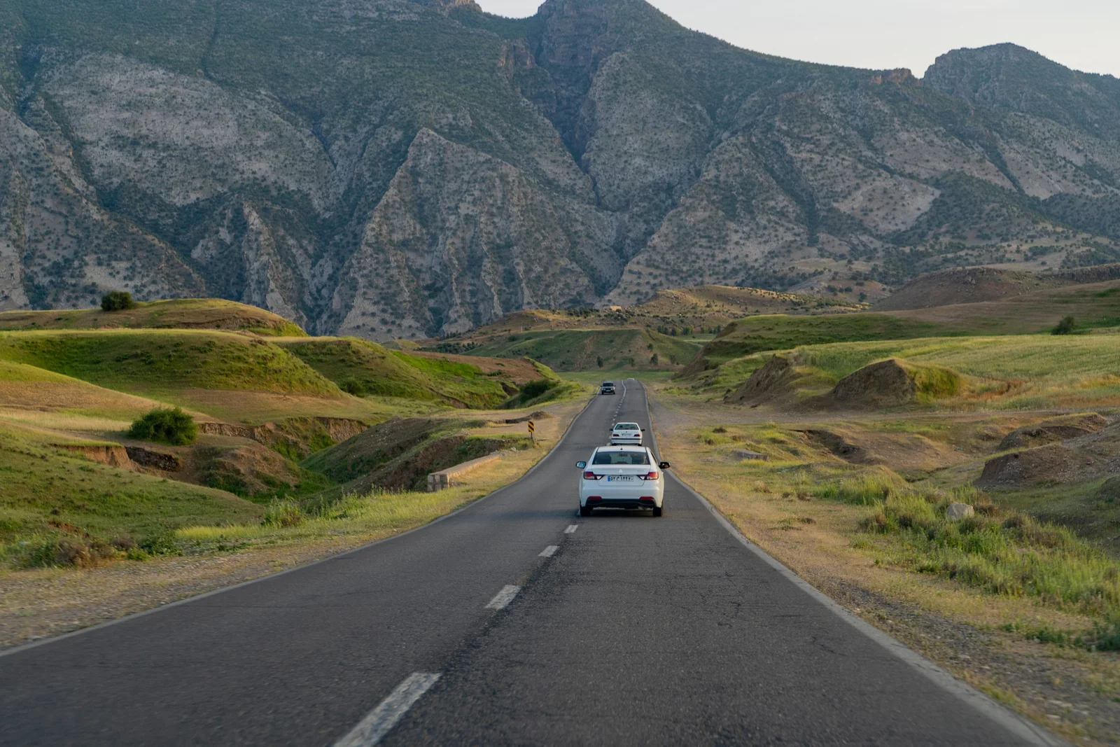 Carros em uma estrada aberta entre montanhas