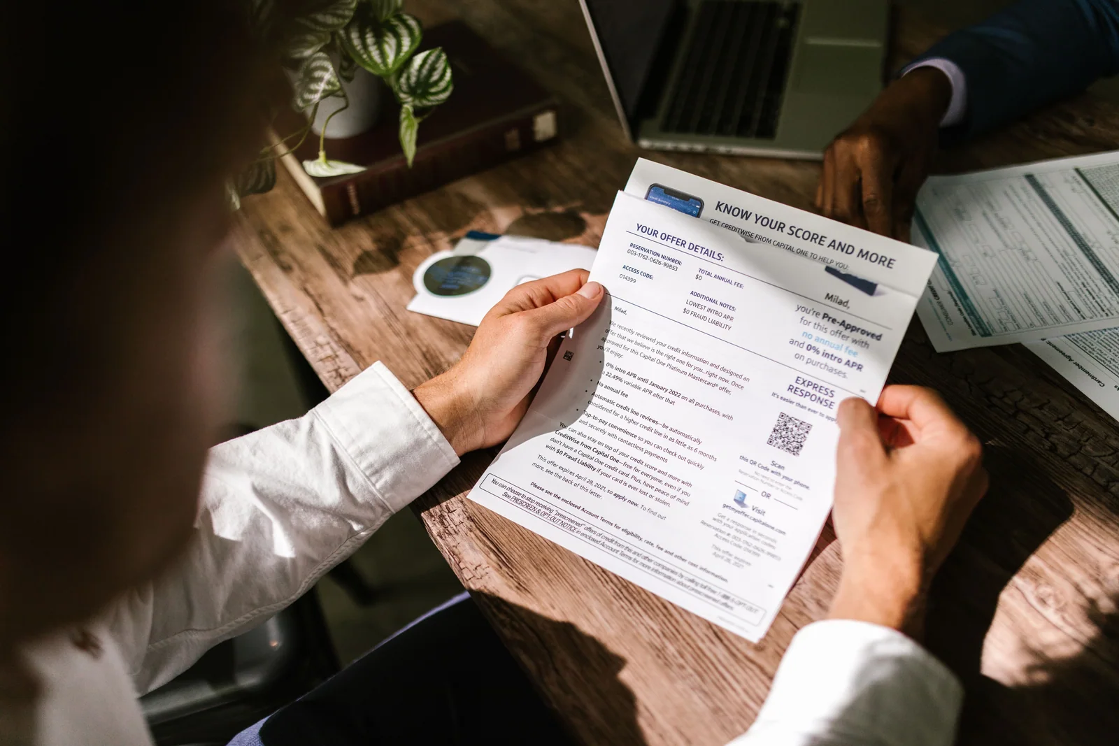 Pessoa examinando uma carta com informações de crédito