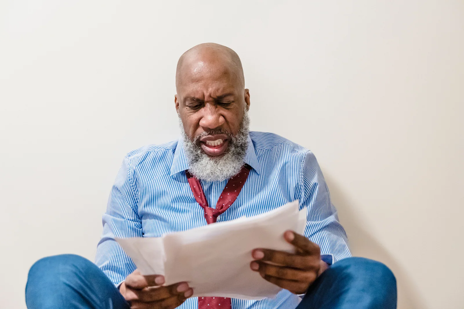 Homem lendo um documento com preocupação, como quem reage a um limite ocupado demais