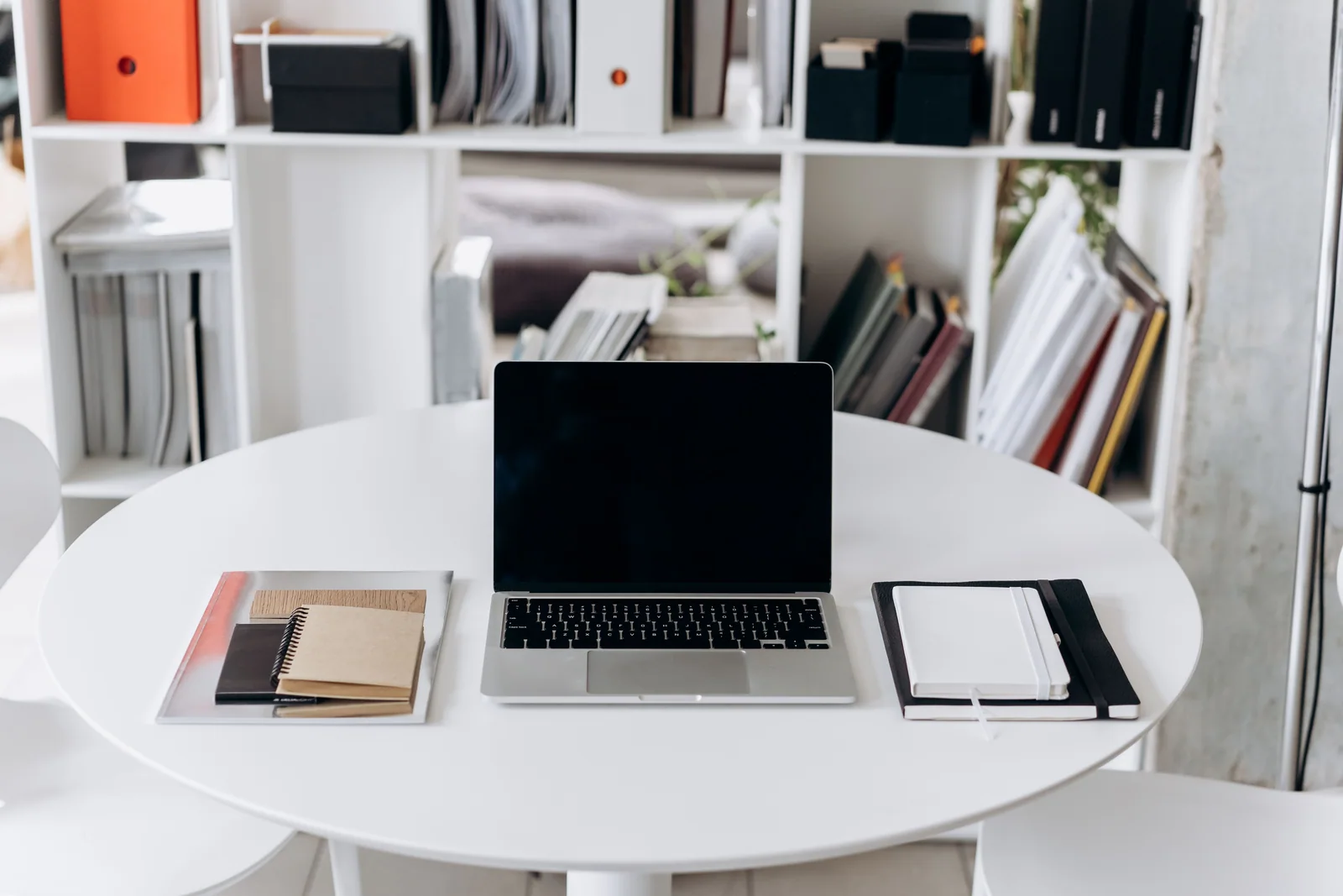 Laptop e cadernos organizados sobre uma mesa clara