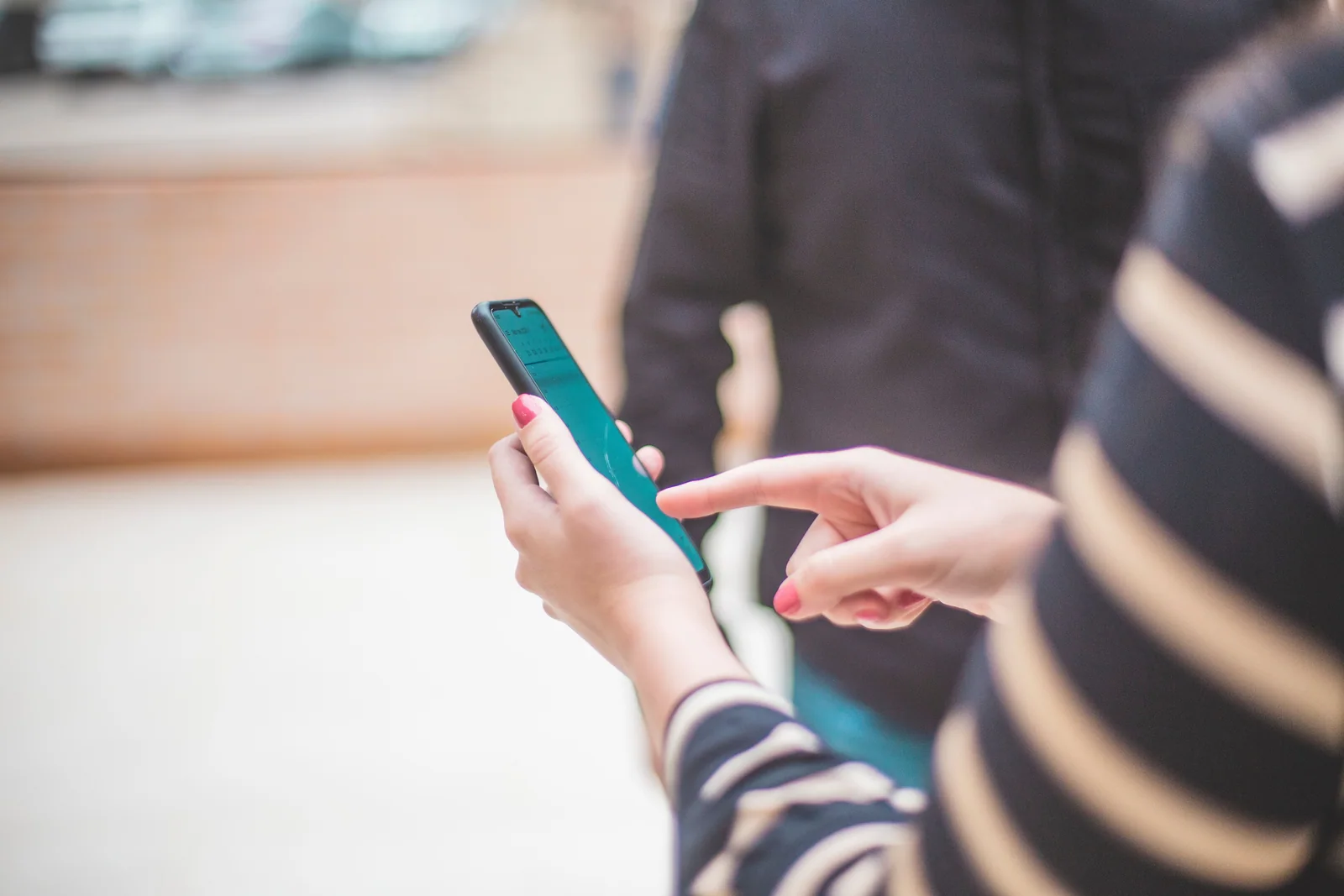 Pessoa conferindo o celular, como no dia em que o primeiro depósito deve aparecer