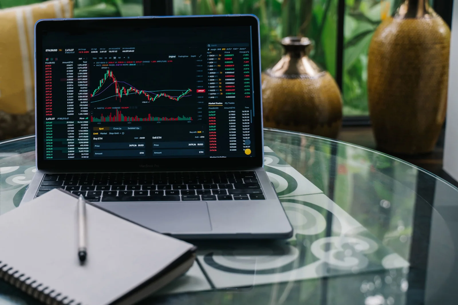 Mãos sobre um laptop com gráfico de investimento e uma calculadora ao lado