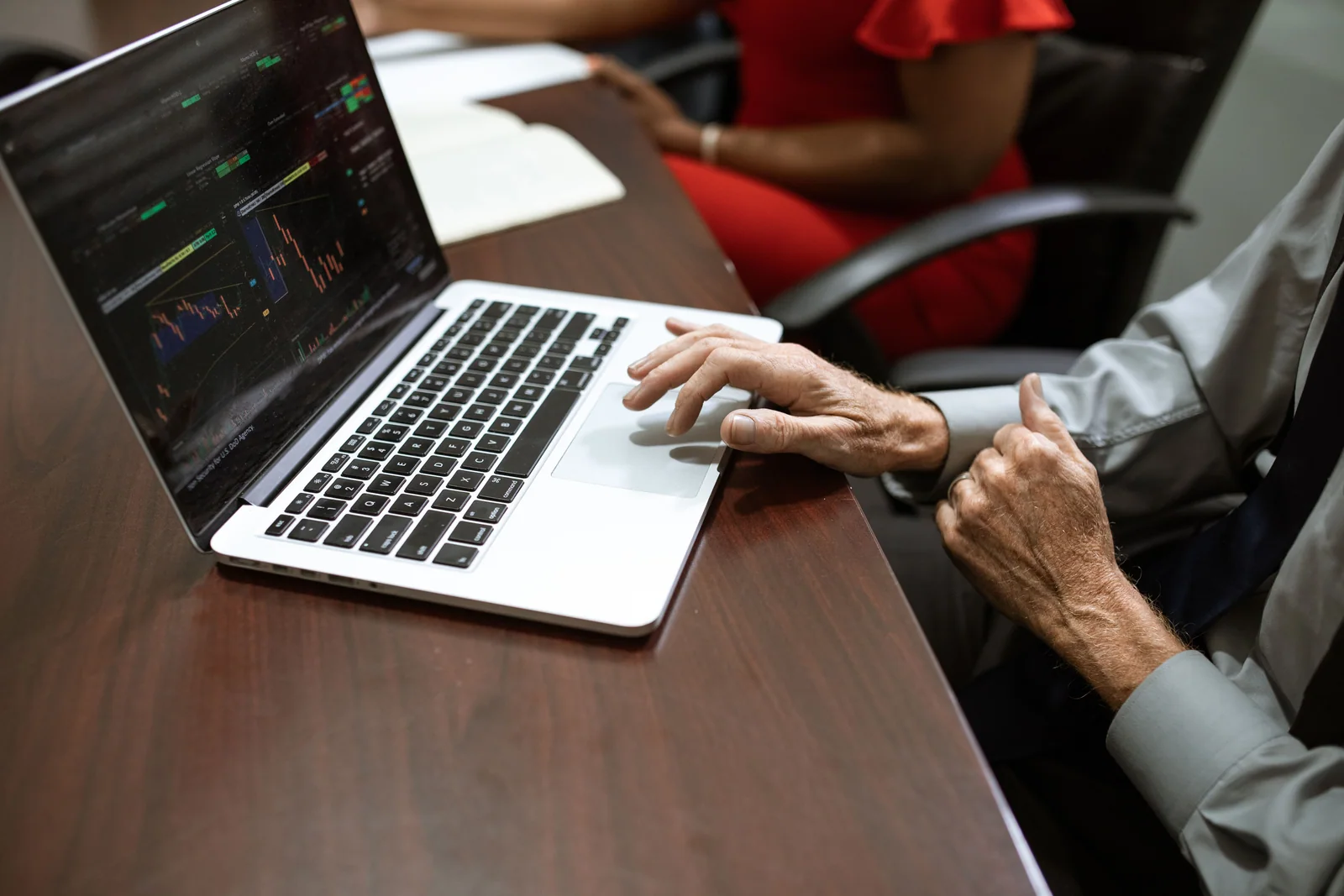 Pessoa planejando investimentos diante de gráficos no computador