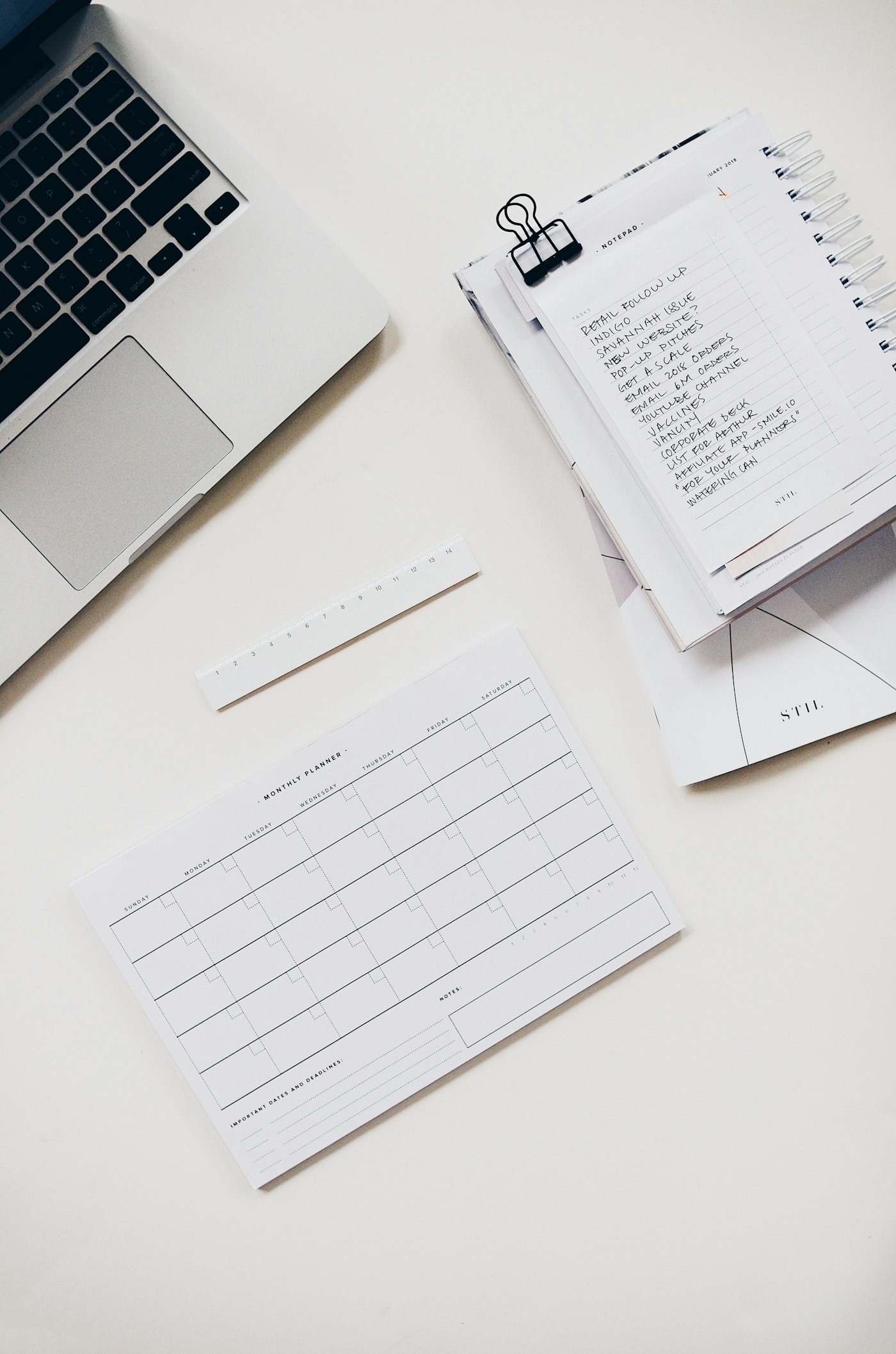 Planejamento financeiro com laptop, caderno e agenda mensal